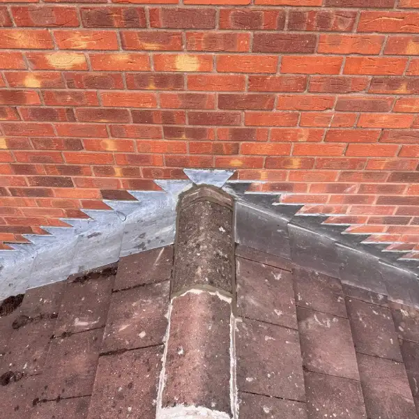 Roof hip junction in Derbyshire with new lead flashing repair against brickwork