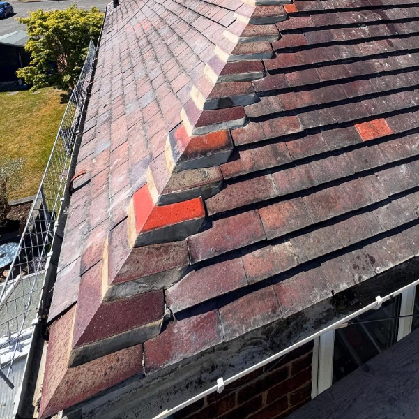 Roof ridge tiling with mixed red tiles in Derbyshire