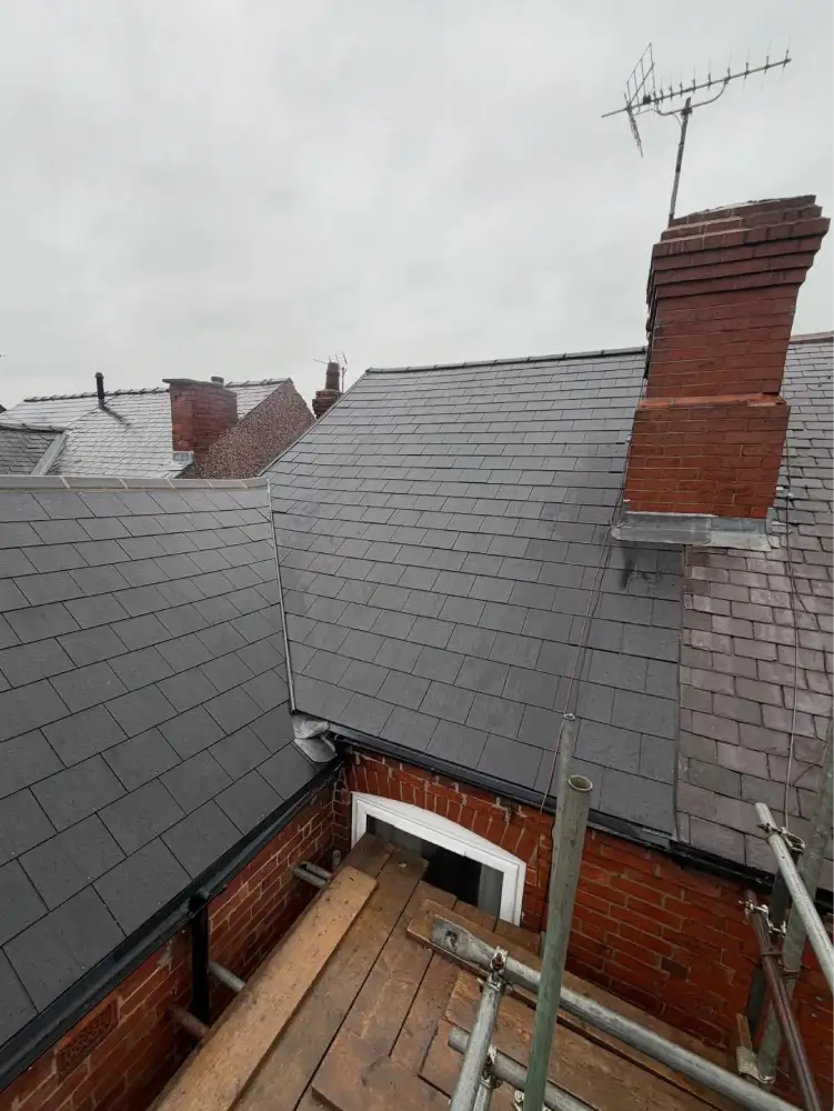 Side view of cement fibre slate reroof with guttering visible